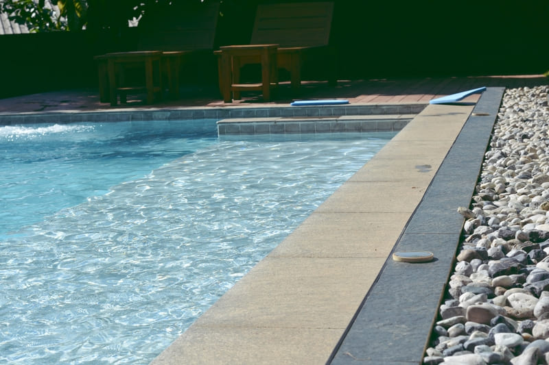 Piscina con zona húmeda y cubierta de piedra