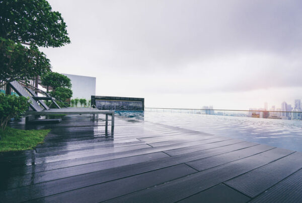 Área de piscina com deck em madeira em dia nublado