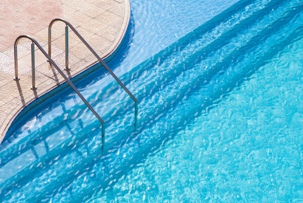 piscina curva com escada embutida e corrimão de inox